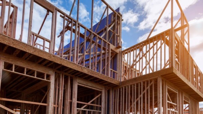 new-house-under-construction-framing-against-a-blue-sky-picture-id1135653561